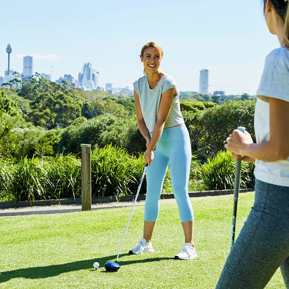 Golfer with a Sydney city backdrop at Moore Park Golf