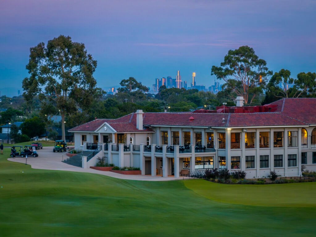 Commonwealth Golf Club clubhouse at dusk with Melbourne skyline — Oakleigh South, Victoria